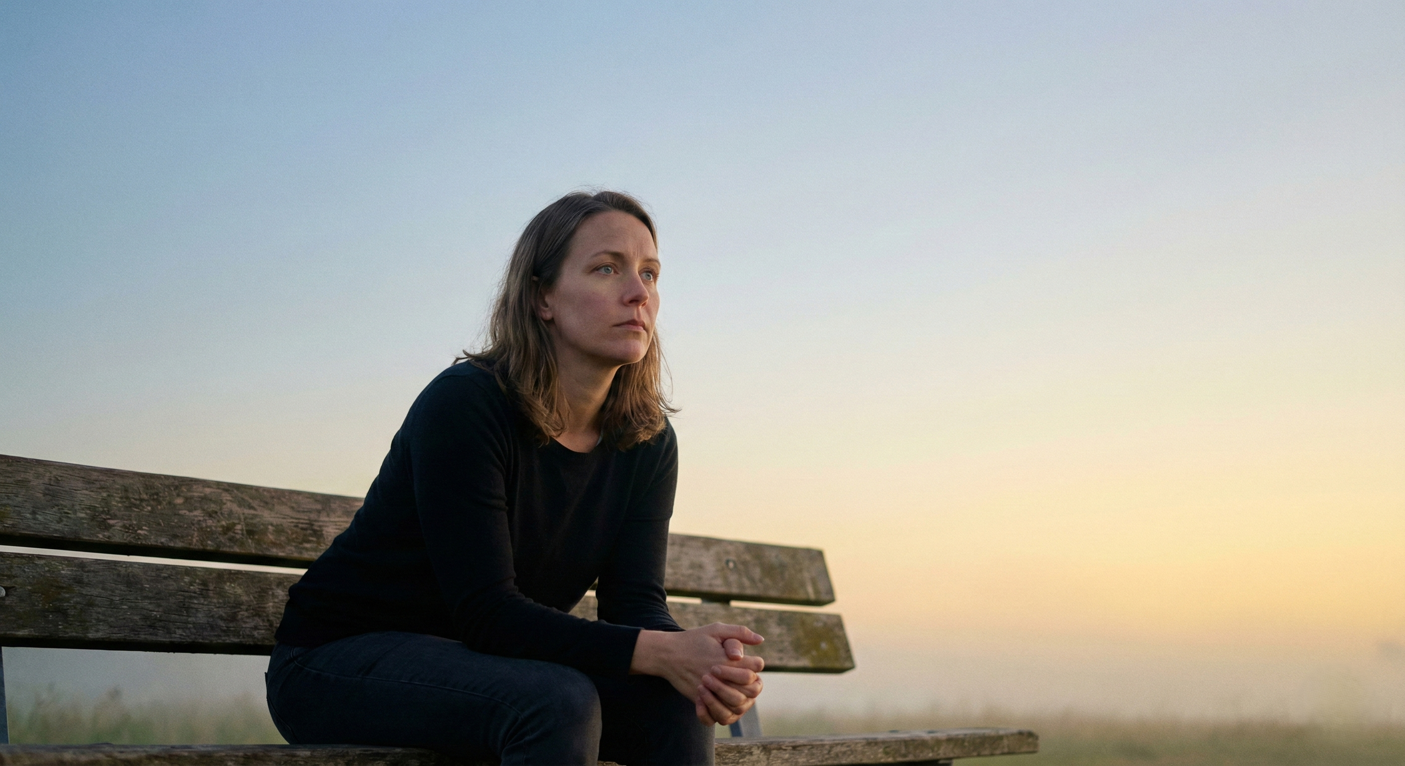 Mujer sentada en una banca del parte reflexionando sobre el tema de la salud mental.
